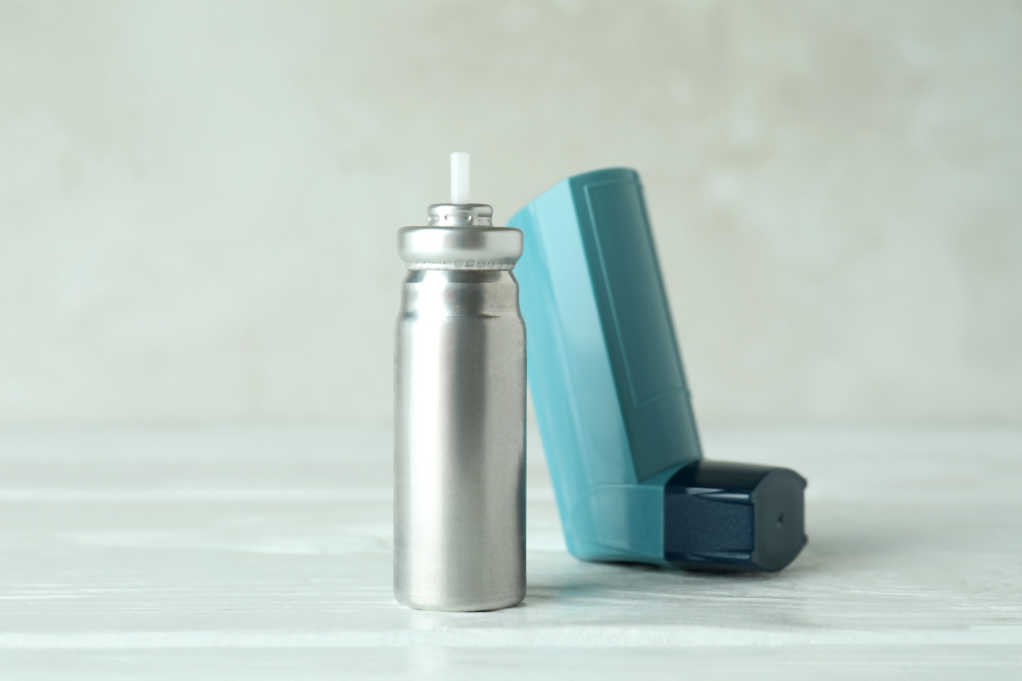 blue asthma inhaler on white wooden table 2021 09 04 10 32 16 utc